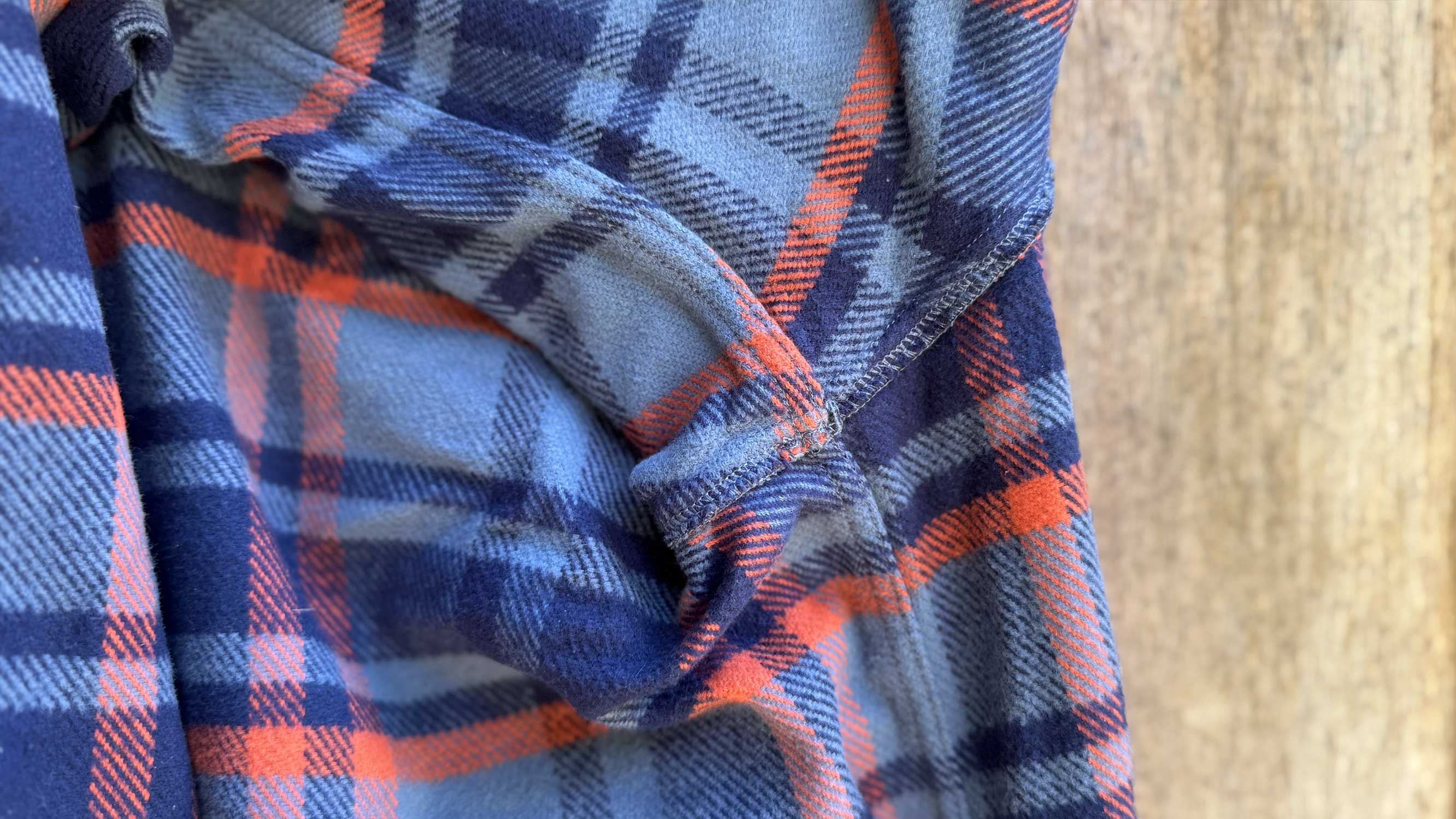 Detailed view of the interior flat-felled stitching on the flannel shirt.