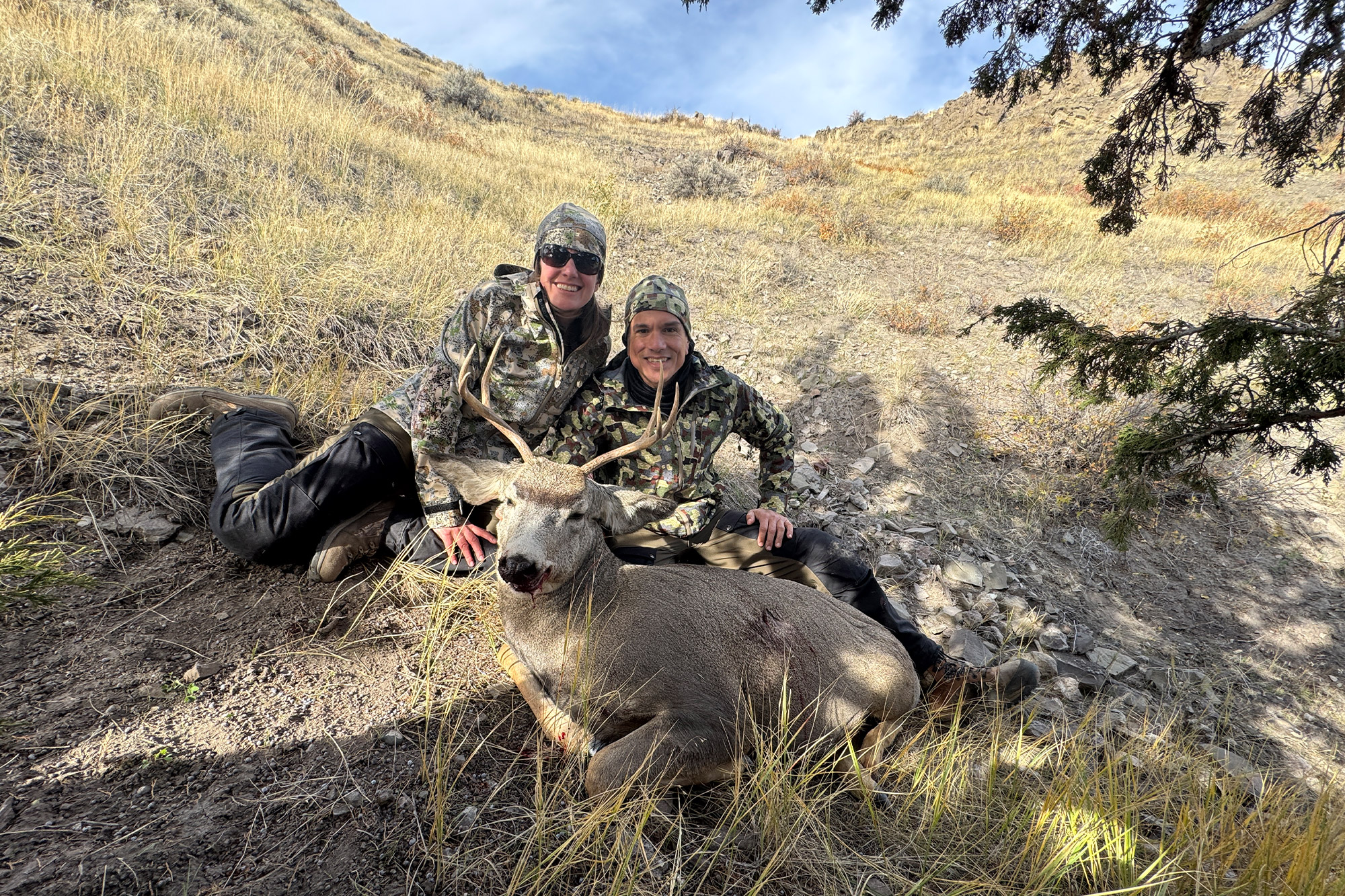 Two female hunters in AllClima jackets posing with a harvested deer.