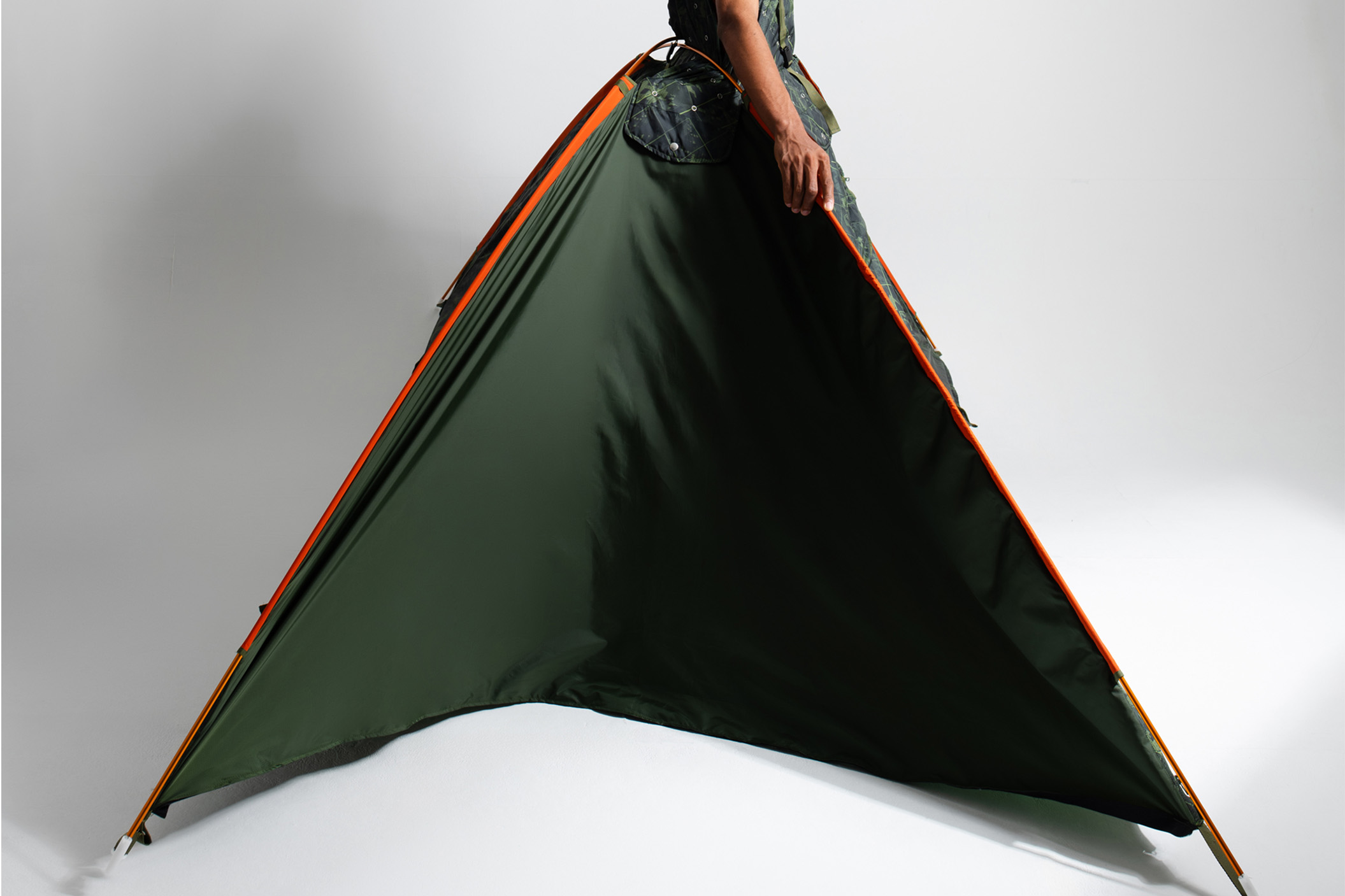 A fashion-forward experimental garment being transformed into a portable shelter.