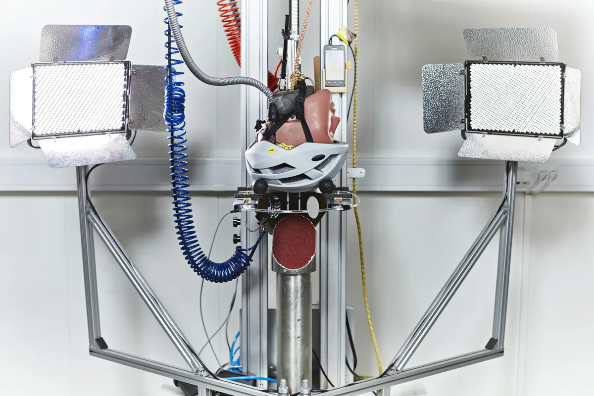 A test dummy head equipped with a helmet inside a MIPS laboratory impact rig.