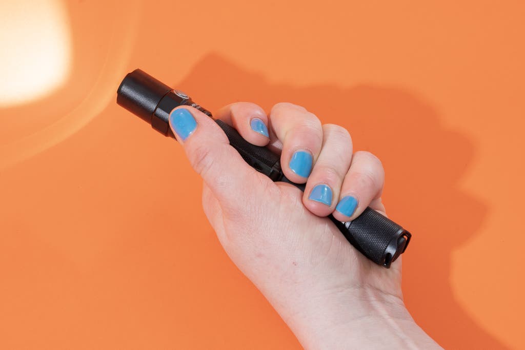A person holding the ThruNite Archer 2A C flashlight to show its handheld size.